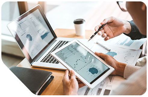 Person reviewing charts on tablet and laptop
